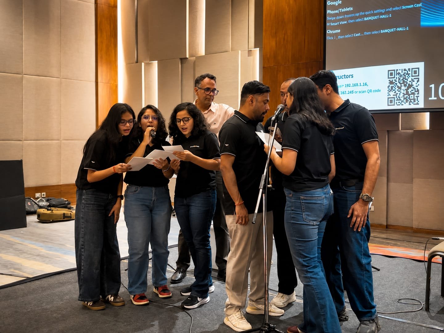 Corporate participants singing together at a YAM Training microphone