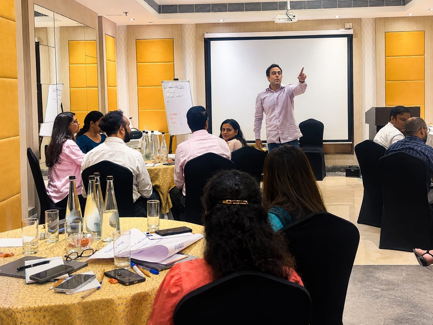 Facilitator leading a corporate learning session at round tables